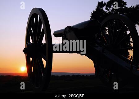 The sun sets on the Gettysburg National Military Park, rendering a cannon from the American Civil War in silhouette and timeless Stock Photo