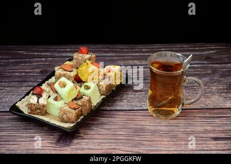 A rectangular plate with a variety of oriental sweets and a cup of hot ...