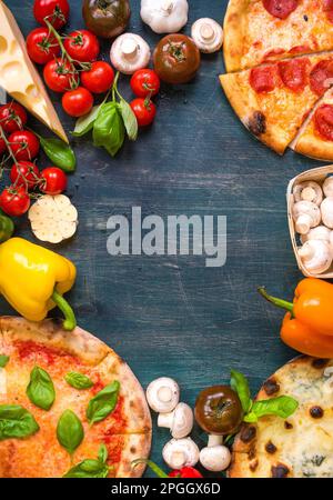 Pizza with assorted toppings and ingredients background. Space for text. Pizza, flour, cheese, tomatoes, basil, pepperoni, mushrooms and rolling pin Stock Photo