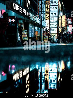 July 16, 2022: Rainy night scene at a red light district in Shinjuku Tokyo, Japan. Streets filled with restaurants, bars and clubs. Stock Photo