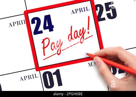24th day of April. Hand writing text PAY DATE on calendar date April 24 and underline it. Payment due date. Reminder concept of payment. Spring month, Stock Photo