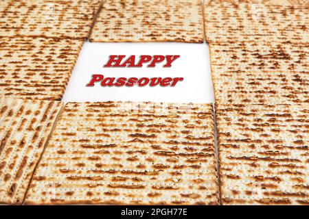 Pesach celebration concept - Jewish holiday Pesach. Frame from square matzah isolated on white background. Happy Passover inscription. Stock Photo