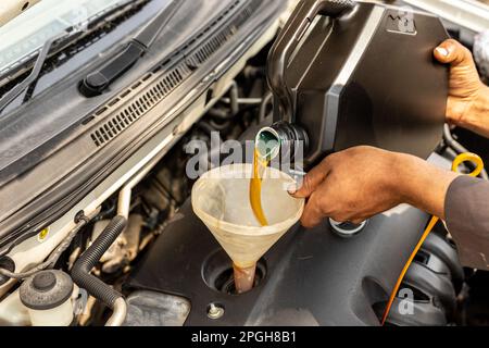 Mechanic pouring motor oil into the car engine Stock Photo