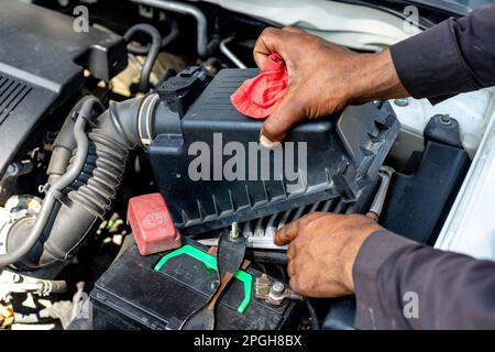 Technician holding and cleaning dirty air filter of a vehicle Stock Photo