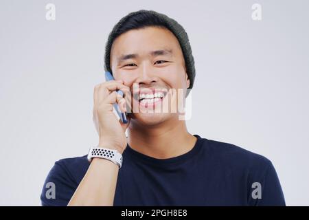 Stay connected to all the lols. Studio shot of a young man using a mobile phone against a grey background. Stock Photo