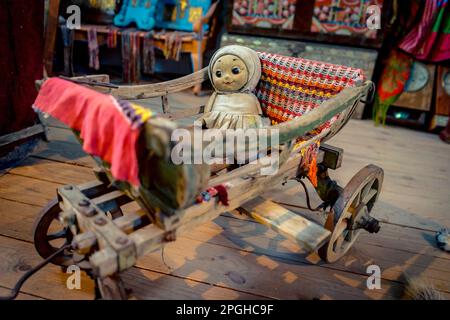 Creepy baby girl doll in a cradle on wheels Stock Photo