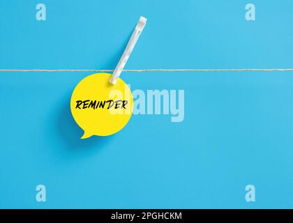 The word Reminder on a speech bubble hanging on clothesline with a clothespin. Reminder note. Stock Photo