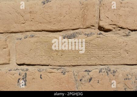 Babylon, Iraq - Feb 11, 2023: Tight Close-up View of a Wall Brick on which is Engraved in Babylonian cuneiform script. Stock Photo