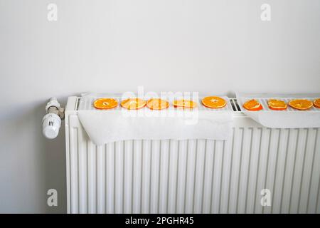 The idea of ​​drying an orange citrus slice on the heater core radiator, herbal tea of winter, healthy Stock Photo