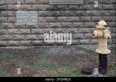 A yellow colored fire hydrant in the courtyard of the Old Joliet Prison in Joliet, United States Stock Photo