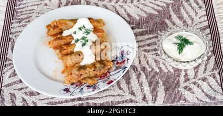 Stuffed cabbage roll with yoghurt sauce and fresh dill, traditional turkish food Stock Photo