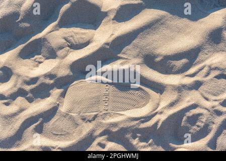 Footprints in the sand with the Adidas brand logo Stock Photo