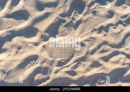 Footprints in the sand with the Adidas brand logo Stock Photo