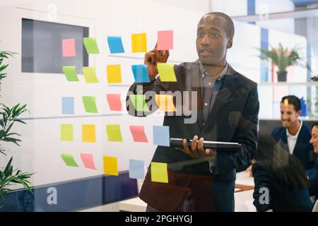 Focused African American businessman in formal suit standing nea Stock Photo