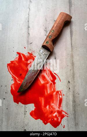 Bloody knife on a wooden table Stock Photo