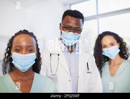 Portrait of surgical team wearing masks, doctor and nurses in a row Stock Photo