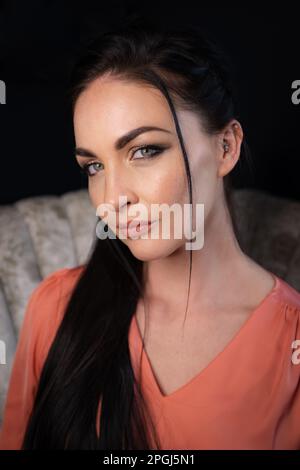 A dark-haired brunette on a Vintage White Chair Stock Photo