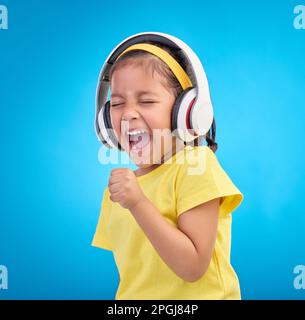 Music, headphones and singing with girl in studio for streaming, mobile radio and audio. Technology, media and youth with child listening isolated on Stock Photo