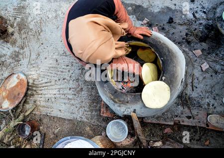 Tunis, Tunisia. 22nd Mar, 2023. Tunis, Tunisia, 22 March 2023. A Tunisian woman bakes the Tabouna bread in a traditional clay oven, before selling it in a market in Tunis. Tabouna is an ancient Tunisian bread made with wheat, semolina, or barley flour and cooked on the walls of a traditional terracotta oven. Tabouna is particularly popular during the Muslim holy month of Ramadan (Credit Image: © Hasan Mrad/IMAGESLIVE via ZUMA Press Wire) EDITORIAL USAGE ONLY! Not for Commercial USAGE! Stock Photo