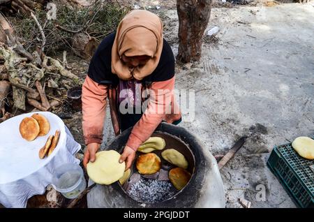 Tunis, Tunisia. 22nd Mar, 2023. Tunis, Tunisia, 22 March 2023. A Tunisian woman bakes the Tabouna bread in a traditional clay oven, before selling it in a market in Tunis. Tabouna is an ancient Tunisian bread made with wheat, semolina, or barley flour and cooked on the walls of a traditional terracotta oven. Tabouna is particularly popular during the Muslim holy month of Ramadan (Credit Image: © Hasan Mrad/IMAGESLIVE via ZUMA Press Wire) EDITORIAL USAGE ONLY! Not for Commercial USAGE! Stock Photo