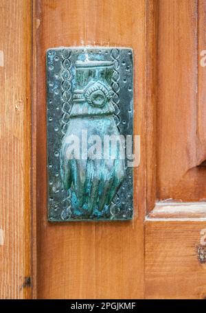 Door furniture (in the shape of a door knocker) seen on the Island of Crete , Greece & one that has aged to an attractive patina. Stock Photo