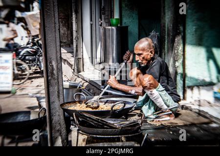 VARANASI, INDIA - NOVEMBER 2 - Unidentified man cooks meal for sale in street restaurant in Varanasi, November 2 2013. Stock Photo
