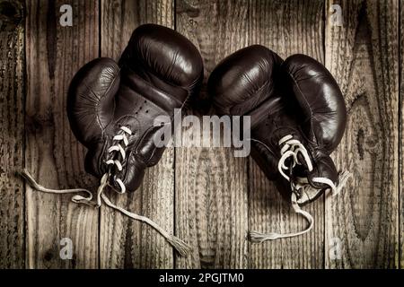 old boxing gloves on wooden background Stock Photo