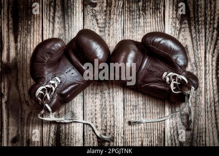 old boxing gloves on wooden background Stock Photo