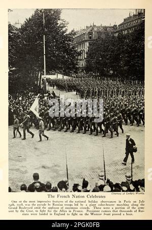 The French Nation Celebrates One ot the most impressive features of the national holiday observances in Paris on July 14th, 1918, was the parade by Russian troops led by a giant color-bearer marching along the Grand Boulevard amid the applause of enormous crowds. from the book ' Deeds of heroism and bravery : the book of heroes and personal daring ' by Elwyn Alfred Barron and Rupert Hughes,  Publication Date 1920 Publisher New York : Harper & Brothers Publishers Stock Photo