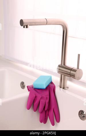https://l450v.alamy.com/450v/2pgk5xj/sponge-and-rubber-gloves-on-kitchen-sink-indoors-2pgk5xj.jpg