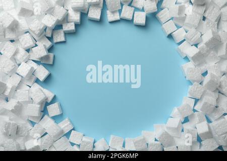 Frame made of styrofoam cubes on light blue background, flat lay. Space for text Stock Photo