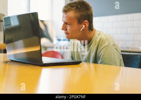 Handsome young invalid disabled man talking on mobile phone in kittchen. Person with disabilities Stock Photo