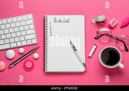 Flat lay composition with unfilled To Do list, computer keyboard and cup of coffee on pink background Stock Photo