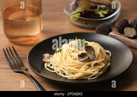 Tasty spaghetti with truffle on wooden table Stock Photo