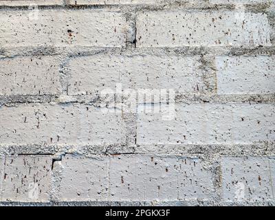 Extreme close-up of a gray-painted brick wall with rough mortar Stock Photo