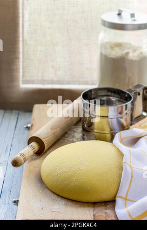 Cooking corn tortillas, buns or flatbread. Raw dough on a wooden board against the background of the window. Selective focus, front view. Homemade hea Stock Photo