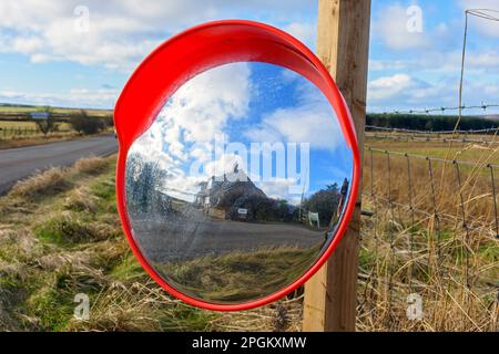 Convex Traffic Mirror, curved wide angle safety mirror, on the main A836 road, near the village of Mey, Caithness, Scotland, UK Stock Photo