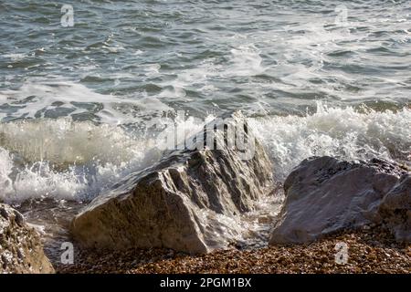 wave splashing over rocks in the sea Stock Photo