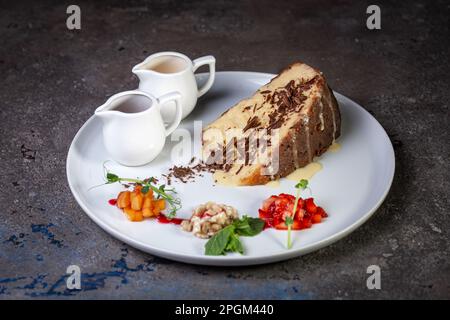 dessert soaked sponge cake with berries on a white plate. Stock Photo