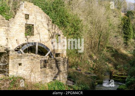 A person rests by the old mill in Jesmond Dene, Newcastle upon Tyne, UK. Stock Photo