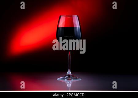 glass of red wine in a red background and red light Stock Photo