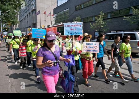 Toronto, Ontario, Canada - 08/25/2013: Protestors holding banners and placards against the Canadian government on the issue of sponsoring children in Stock Photo