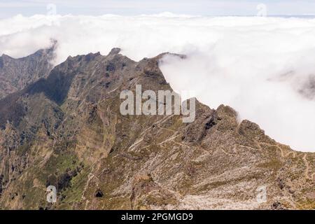 Drone photography of mountain peaks and stopped clouds by mountain range during summer sunny day. High angle view Stock Photo