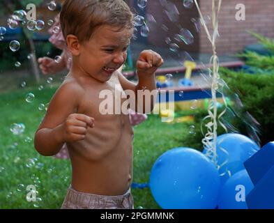 Incredibly happy child. A fun holiday with balls and bubbles Stock Photo