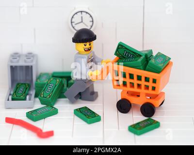 Tambov, Russian Federation - March 23, 2023 A Lego burglar minifigure stealing money from a safe using a shopping cart. Stock Photo