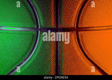 Closeup detail of basketball ball texture background. Green and orange neon. Banner Art concept Stock Photo