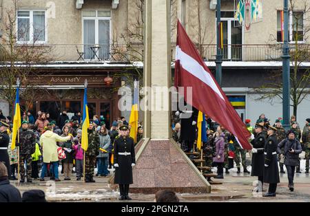 Flags of Latvia and Ukraine flags waving together during a flag raising in an official ceremony with soldiers Stock Photo