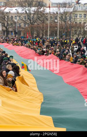 Vilnius  Lithuania - March 11 2022:  Huge Lithuanian flag along Gedimino avenue in Vilnius, carried by people with Lithuanian and Ukrainian flags Stock Photo