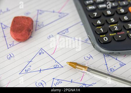 A Child's Math (Geometry) Homework Or Exam, With Calculator, Pen And Eraser Stock Photo