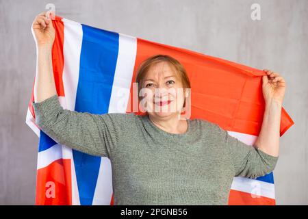 Happy elderly woman posing with national flag of Norway Stock Photo